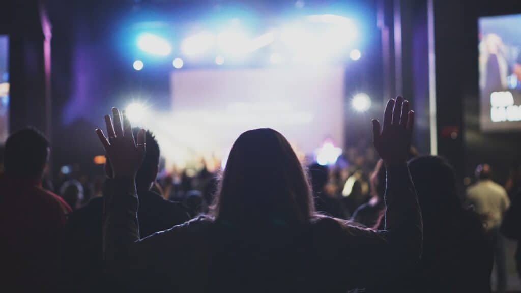 woman raising hand in worship service