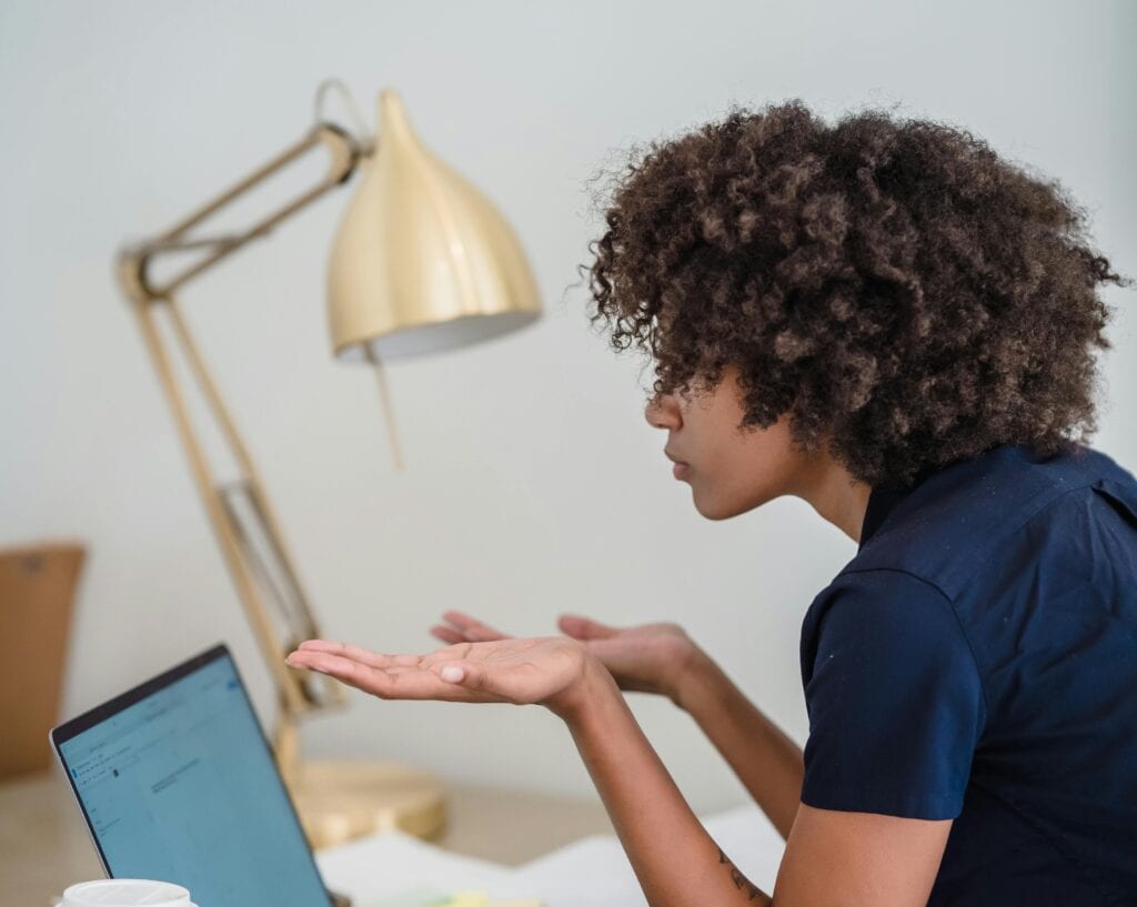 woman looking at computer palms uplifted in confusion