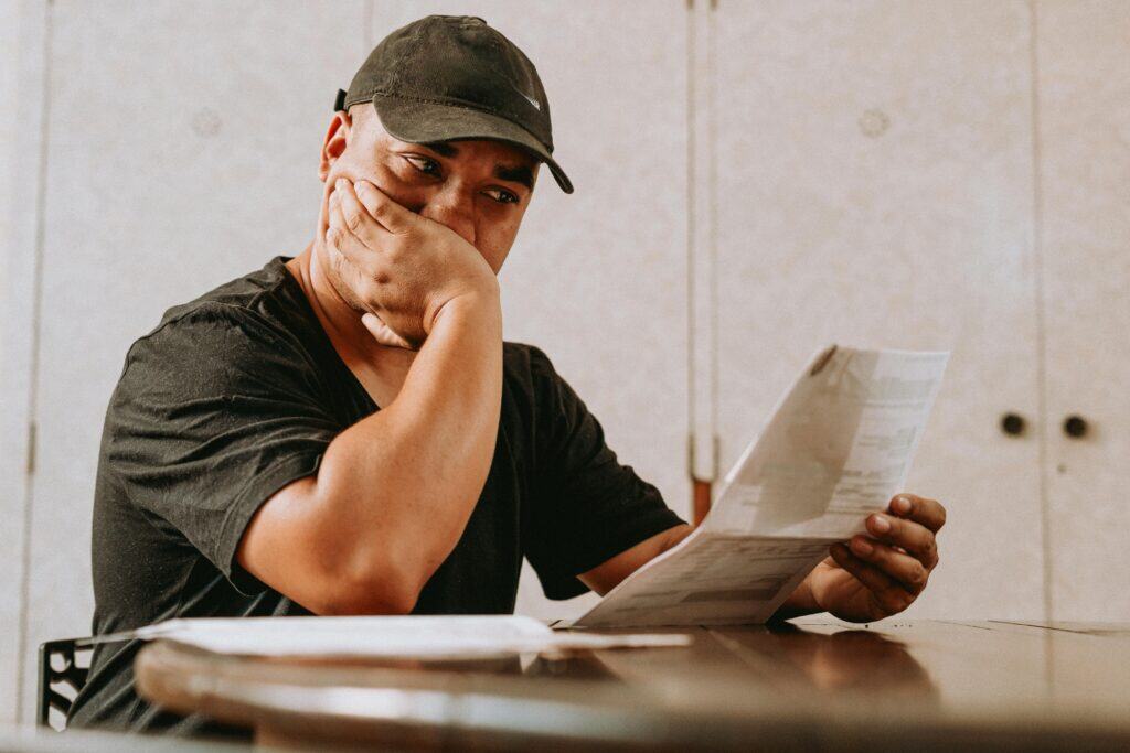 man looking at bill concerned hand over mouth