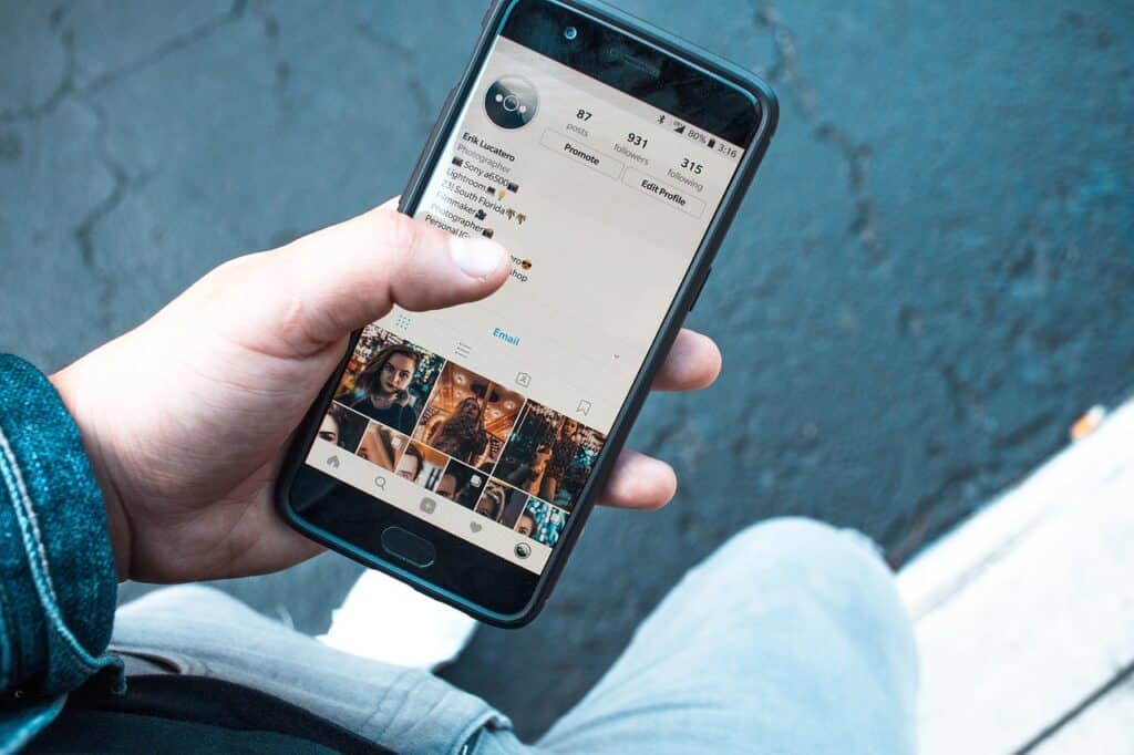 Man's hand phone looking at social media page